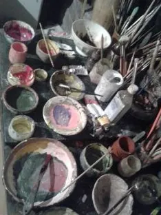 Brushes and bowls of mixed paint on a worktable